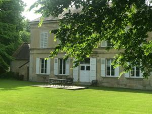a house with a picnic table in the yard at La Fresnée chambres d'hôtes in Mosles