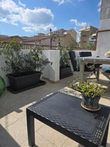 a patio with a table and potted plants on a roof at Appartamento Dancardi in Quartu SantʼElena
