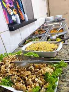 a buffet with many plates of food on a counter at HOTELSÃORAFAEl in Água Boa