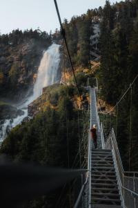 a man standing on a suspension bridge over a waterfall at MYALPS Pure in Oetz