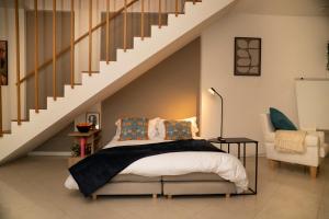 a bedroom with a bed and a staircase at Corte Cavour Duplex Gallarate centro, Wifi e Garage in Gallarate