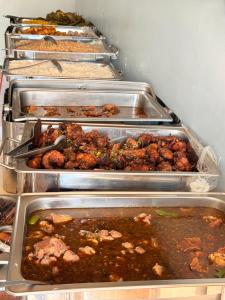 a row of trays filled with different types of food at BUDDIEZ hotel limited in Kampala