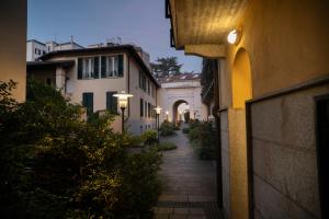 an alleyway between two buildings with street lights at Corte Cavour Duplex Gallarate centro, Wifi e Garage in Gallarate