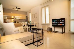 a living room with a couch and a tv in it at Corte Cavour Duplex Gallarate centro, Wifi e Garage in Gallarate