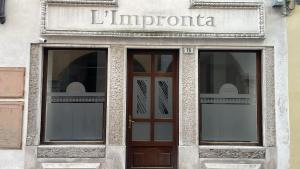 a store front with a sign above the doors at l'impronta in Gorizia