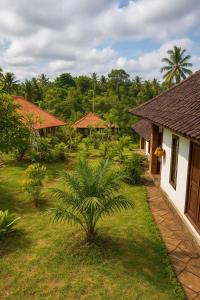 a house with a palm tree in front of a yard at Indra Yoga Retreat in Selemadeg