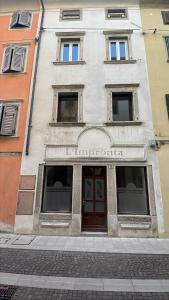 a building with a sign on the front of it at l'impronta in Gorizia