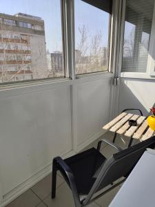 a chair and a table in a room with windows at Goce 20 New Belgrade,near hotel Jugoslavija in Tošin Bunar