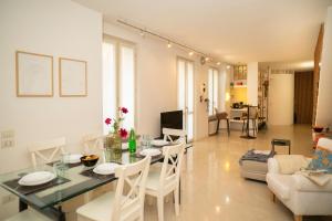 a dining room and living room with a table and chairs at Corte Cavour Duplex Gallarate centro, Wifi e Garage in Gallarate