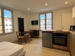 a room with a kitchen with a bed and a table at Les Suites Villeneuve - 2 in Le Puy-en-Velay