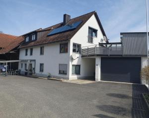 a white house with solar panels on the roof at Ferienwohnung am Schloss in Königstein in Kürmreuth