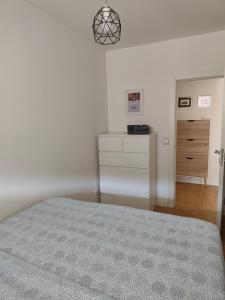 a white bedroom with a bed and a dresser at Goce 20 New Belgrade,near hotel Jugoslavija in Tošin Bunar