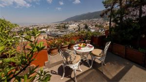 Ein Tisch und Stühle auf einem Balkon mit Aussicht in der Unterkunft Kitapevi Hotel in Bursa