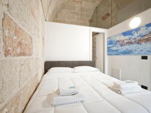 a bedroom with two beds and a stone wall at Azzurro A Mare in Polignano a Mare