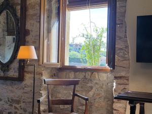 Ein Holzstuhl steht vor einem Fenster in der Unterkunft Loft in Begur