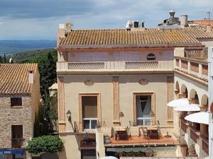 ein großes Gebäude mit einem Balkon mit Sonnenschirmen in der Unterkunft Loft in Begur