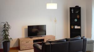 a living room with a couch and a flat screen tv at Alojamento Local Pando in Aveleda
