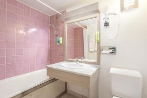 a pink bathroom with a sink and a toilet at Karibea Squash Hôtel in Fort-de-France +108 photos