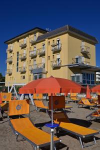 a group of chairs and umbrellas in front of a building at Hotel Biagini in Rimini