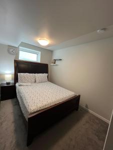 a bedroom with a bed and a clock on the wall at Mary's Luxury Suite in Winnipeg