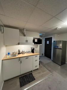 an empty kitchen with a sink and a refrigerator at Mary's Luxury Suite in Winnipeg
