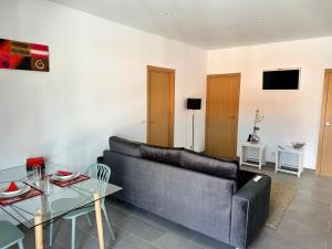 a living room with a couch and a glass table at Capelas Pdl Apartment in Ponta Delgada