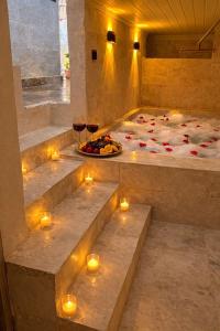 a room with candles and a bed with wine glasses at Masal Cave Suites - Where Story Begins in Ürgüp
