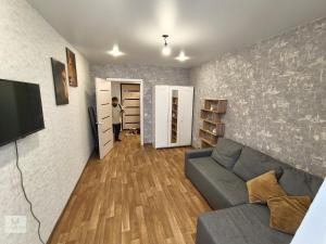 a man standing in a living room with a couch at Rassvet in Lenīnogorsk