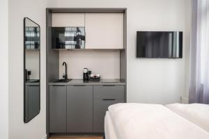 a small kitchen with a sink and a microwave at Homaris Rummelsburg Studios in Berlin +52 photos