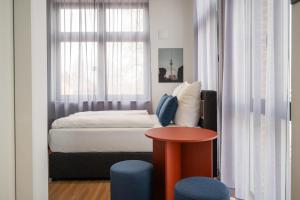 a small bedroom with a bed and a table at Homaris Rummelsburg Studios in Berlin