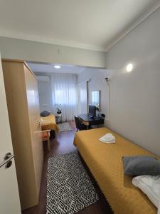 a hotel room with two beds and a desk at Hostel Jardins de São Luís in Setúbal