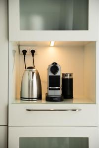a cupboard with a tea kettle and a toaster at Lighthouse View - Sol Marina in Wiślinka