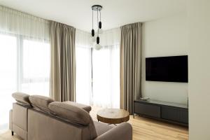a living room with a couch and a table at Lighthouse View - Sol Marina in Wiślinka +7 photos