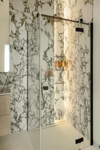 a shower with a glass door in a bathroom at Lighthouse View - Sol Marina in Wiślinka