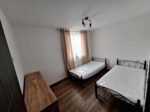 a room with two beds and a wooden table at Апартамент Бохо 2 in Primorsko