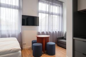a room with a bed and a table and a couch at Homaris Rummelsburg Studios in Berlin