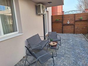three chairs and a table on a patio at Апартамент Бохо 2 in Primorsko