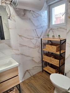 a bathroom with marble walls and a sink and a toilet at Апартамент Бохо 2 in Primorsko