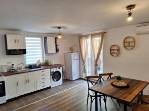 a kitchen and dining room with a table and a refrigerator at Апартамент Бохо 2 in Primorsko