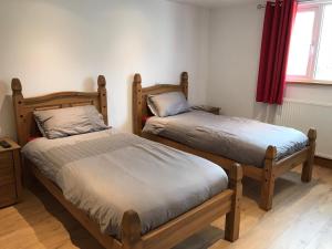 two twin beds in a room with a window at Y Llew Coch Tregaron in Tregaron
