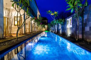 吉利特拉旺安Blue Marlin Dive Resort Trawangan的夜晚建筑物旁边的游泳池