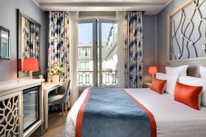 a hotel room with a bed and a desk and a window at Rochester Champs Elysees in Paris +60 photos