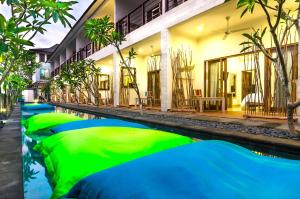 吉利特拉旺安的住宿－Blue Marlin Dive Resort Trawangan，绿色和蓝色建筑前的游泳池