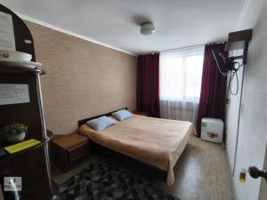 a small room with a bed and a window at Rassvet in Lenīnogorsk +230 photos
