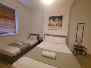 two beds in a small room with a mirror at Blyth 1 Bedroom Apartment in Blythe