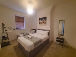 a bedroom with a large bed and a mirror at Blyth 1 Bedroom Apartment in Blythe