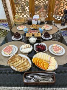 a table filled with different types of food on plates at Khalid Boutique in Bukhara