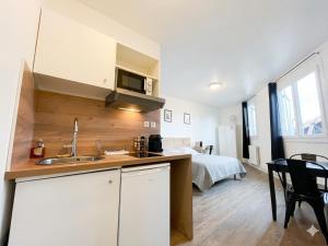 a kitchen and living room with a bed in the background at Libourne centre in Libourne
