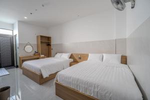 a bedroom with two beds with white sheets at An Thy HOTEL in Vung Tau