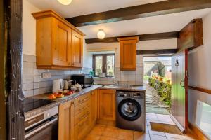 a kitchen with wooden cabinets and a washer and dryer at 2 Bed in Clitheroe oc-la156 in Harrop Fold